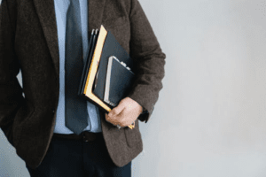 a man holding files and a notebook