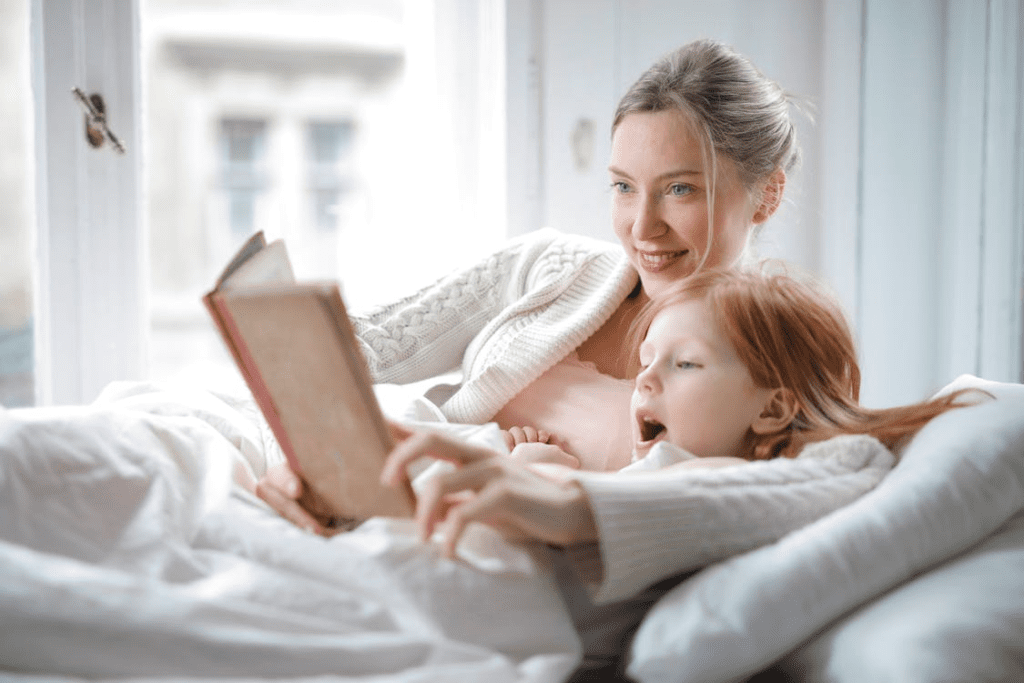 Mother and daughter reading a book in bed