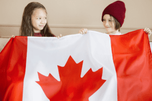 Two Kids holding the Canadian Flag